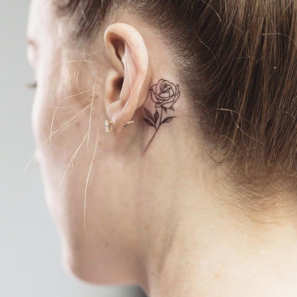 A Woman With A Black Rose Tattoo On Her Ear And Behind The Ear Is A Chain A Woman With A Black Rose Tattoo On Her Ear And Behind The Ear Is A Chain